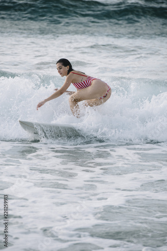 Young woman surfing the wave on his surfboard © karrastock