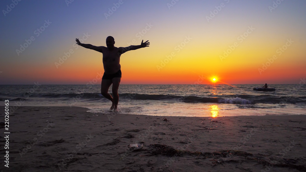 Unrecognizable silhouette walk out of ocean sunset water with hands wide open, FREEDOM CONCEPT, steadicam cinematic shot