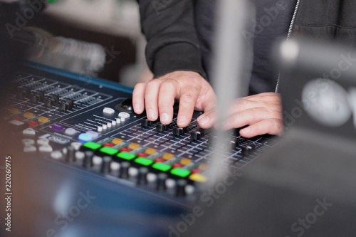 The sound engineer's hands on the mixing console during the concert
