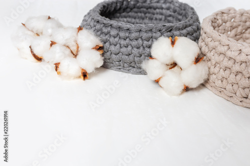 Spa set. Items for spa on white concrete background with copy space. Spa concept with knitted box, cotton flowers. Selective focus.