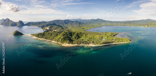 Aerial drone panoramic view of a beautiful tropical beach and reef in the evening (Las Cabanas, Palawan)