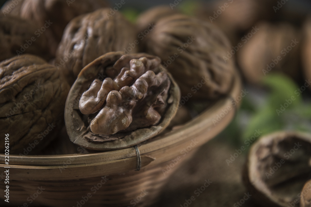 Walnuts in wooden bowl. Whole walnut on table Walnuts in wooden bowl. Whole walnut on table