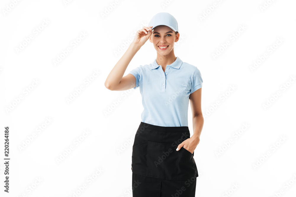 Beautiful smiling girl in blue polo T-shirt and cap joyfully looking in camera over white background isolated