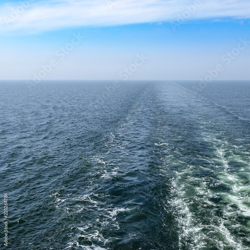 Trail in the sea from cruise ship. Enless ocean and horizon. Background with copy space for text. © Forenius