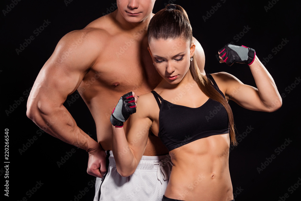 Fototapeta premium Woman flexes bicep near man.