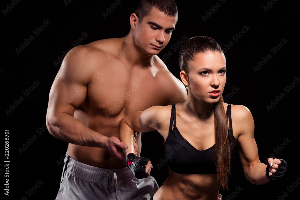 Fototapeta premium Bodybuilder holding fit girl's arm.