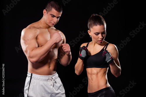 Muscular couple in poxing pose. © yuriygolub