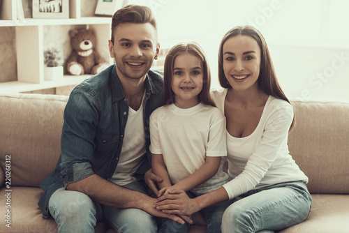 Portrait of Young Happy Family Sitting on Sofa