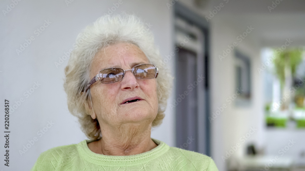 Portrait of elderly white sad woman sitting and thinking outdoors Portrait of elderly white sad woman sitting and thinking outdoors