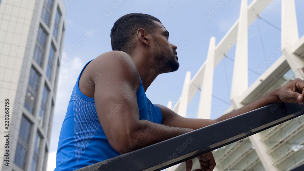 Naklejka premium Tired handsome athlete having rest after training, working hard to achieve goals