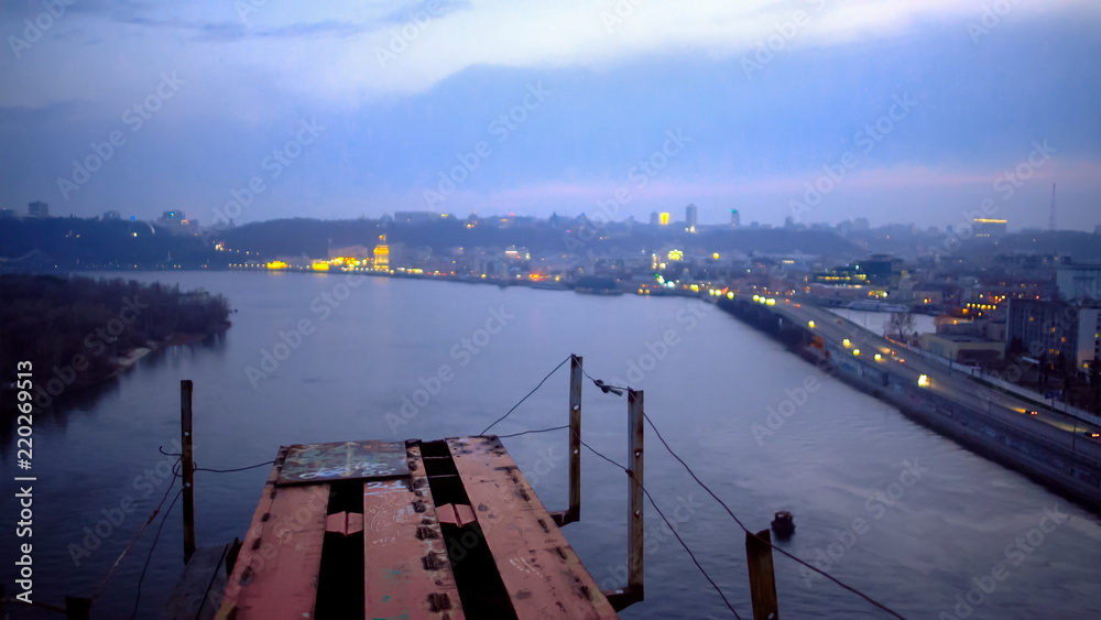 Amazing view of night city from edge of unfinished bridge, height and beauty