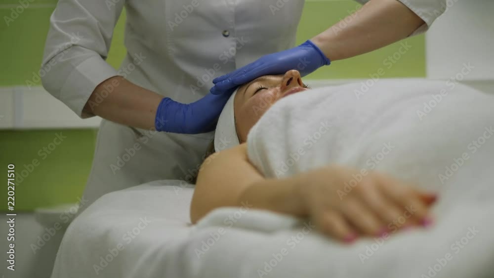 Cosmetologist in medical gloves makes relaxing massage for woman in beauty clinic Cosmetologist in medical gloves makes relaxing massage for woman in beauty clinic