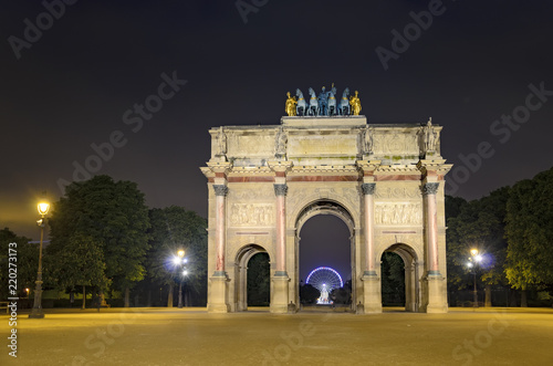 Arc de Triomphe at the Place du Carrousel in Paris in the night with Ferris wheel at Concorde at background