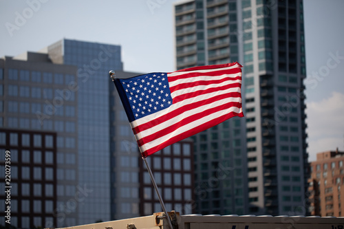 Flying United States of America flag with buildings in background