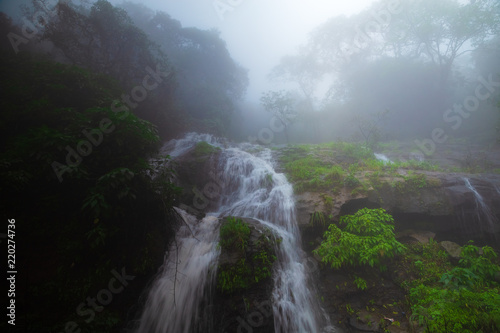 A scenic waterfall in the forest, a rainy foggy/misty waterfall landscape in India.