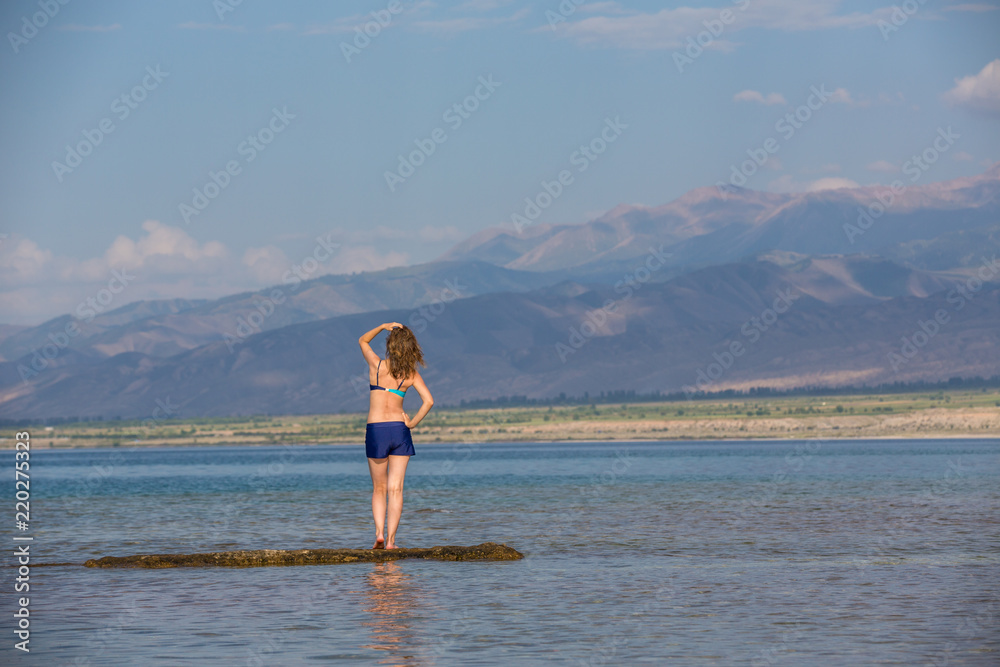 girl in a swimsuit on a mountain lake
