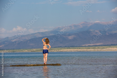 girl in a swimsuit on a mountain lake