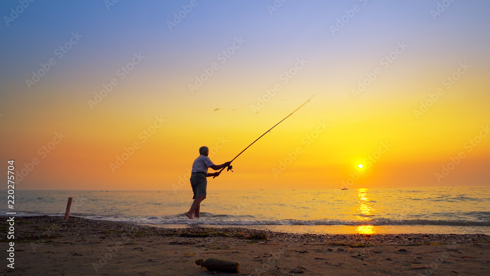 Fisherman catches a fish. Hands of a fisherman with a spinning rod reel in hand closeup