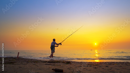 Fisherman catches a fish. Hands of a fisherman with a spinning rod reel in hand closeup © zefart