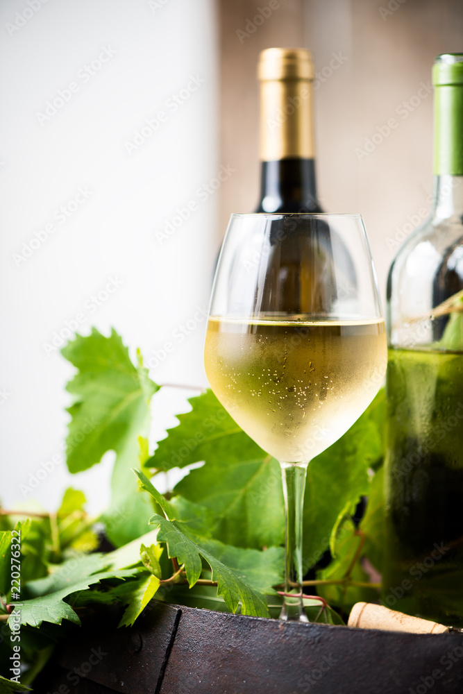 Glass of white wine on a barrel on white background