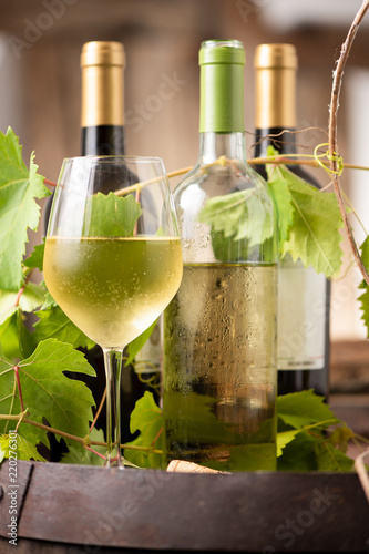 Glass of white wine on a barrel on white background