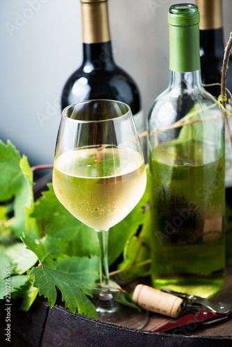 Glass of white wine on a barrel on white background