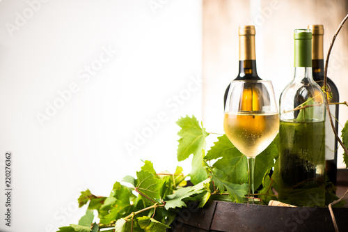 Glass of white wine on a barrel on white background