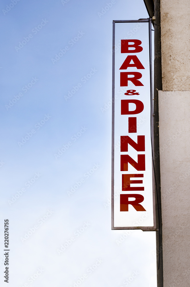 Neon lit BAR DINNER sign in daylight Neon lit BAR DINNER sign in daylight
