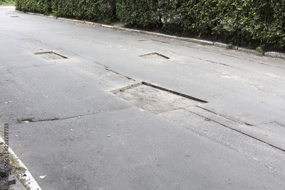Fototapeta premium bad asphalt road, repair of asphalt road, pit on the road