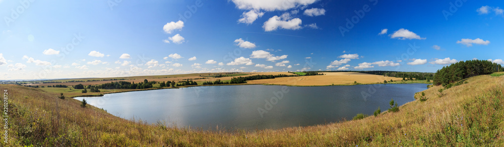 Countryside landscape with the lake and wheat field 