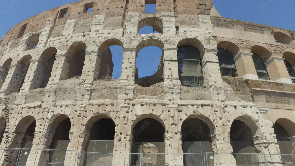 Outdoor facade  of Colosseum, people. Ancient landmark of Rome