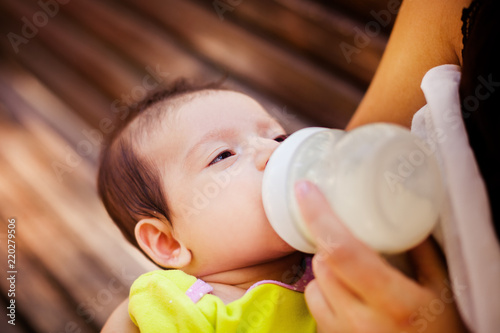 image of the woman feeding baby from children's small bottle photo