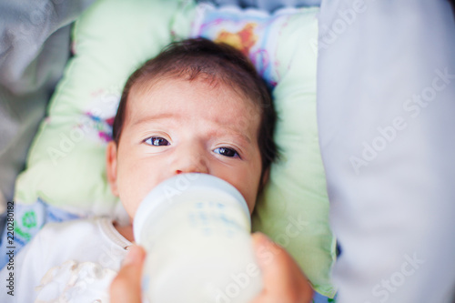 The image of woman feeding her baby from a bottle photo