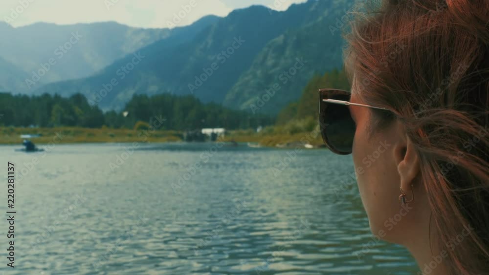 Young woman looking on mountains and lake Young woman looking on mountains and lake