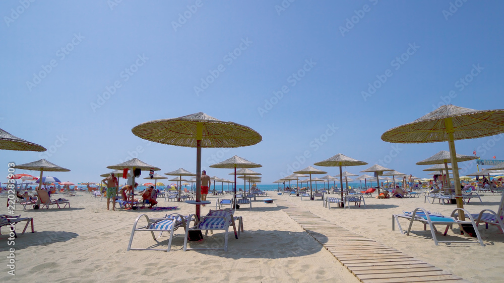 beach umbrellas and sunbeds on summer vacation resort