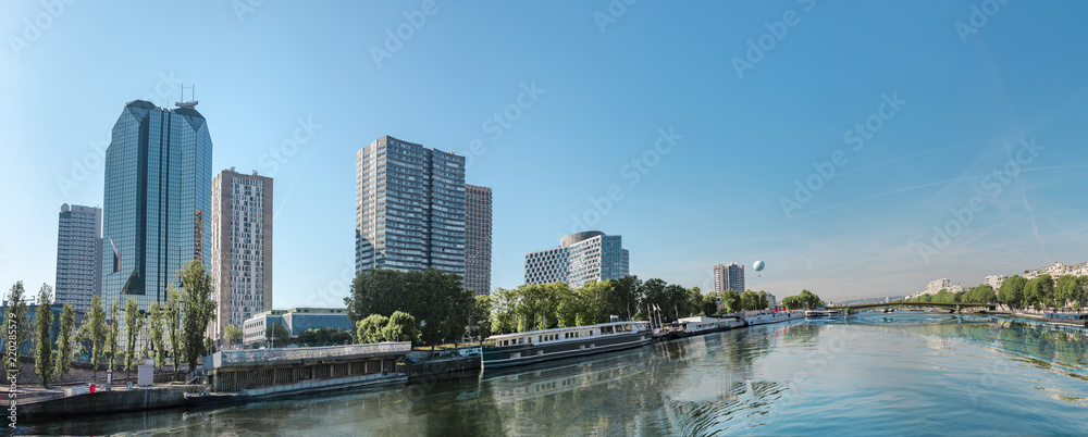 Boats on Seine river in Paris, France. View from place of The Statue of Liberty to modern buildings district