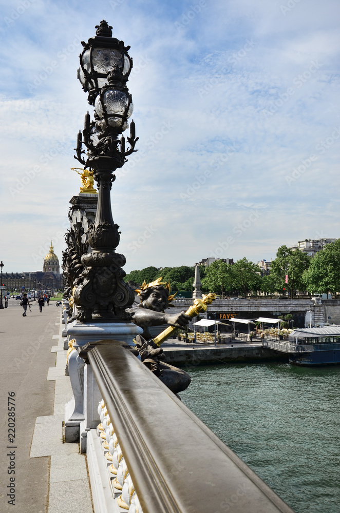 Row of lampposts along Pont Alexandre III with dome of Hotel des Invalides beyond, Paris, France