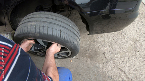 Kocani, Macedonia - 24 Jun, 2018: Low Section Of Male Mechanic Repairing Car’s Tire In Repair Shop photo