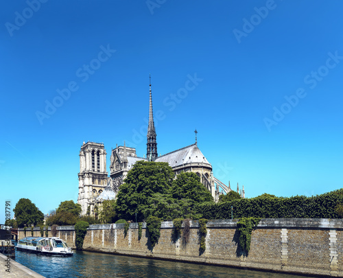Notre Dame de Paris cathedral with cruise ship in Seine river in Paris, France