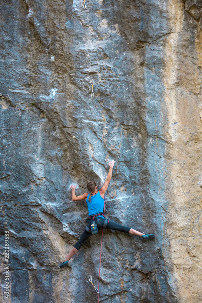 The climber is training to climb the rock. The climber is training to climb the rock.