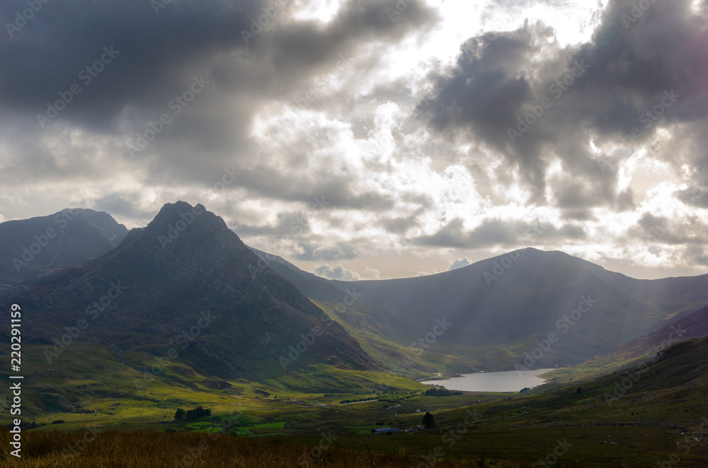 Evening sun rays fall on Mount Tryfan and  Llyn Ogwen lake in Snowdonia National Park, North Wales