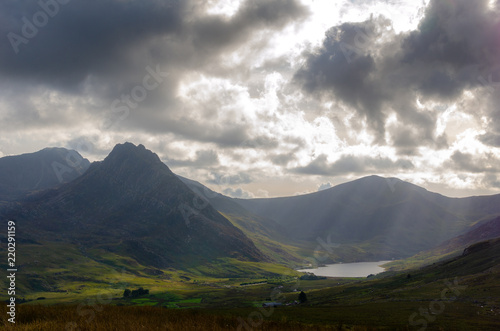 Evening sun rays fall on Mount Tryfan and Llyn Ogwen lake in Snowdonia National Park, North Wales