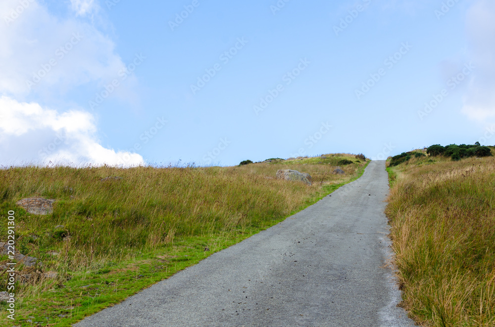 A country road under a blue sky in summer. Photo taken in Snowdonia, Wales