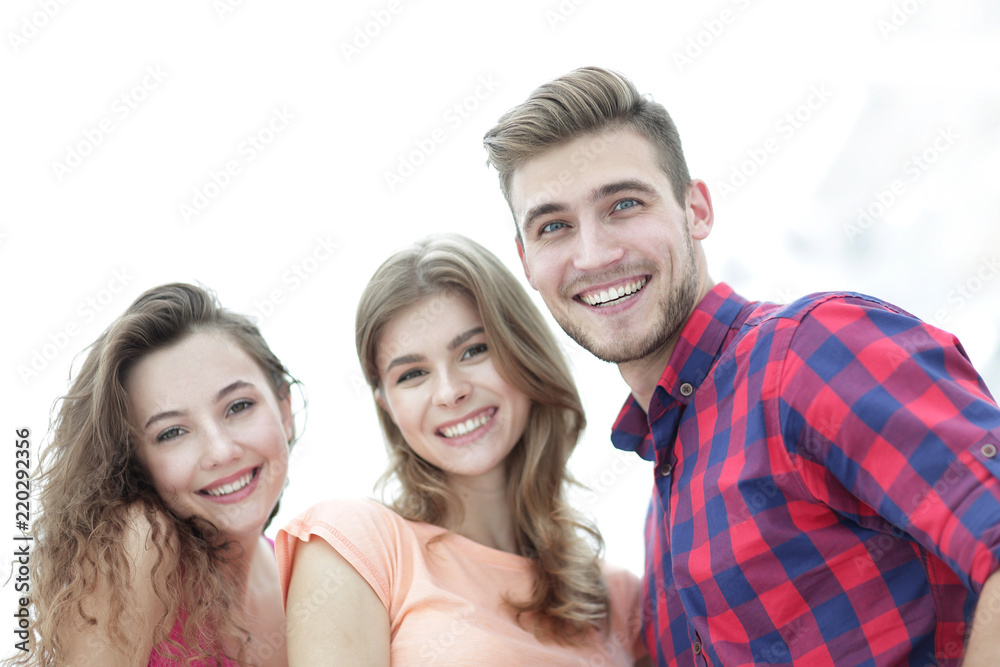 closeup of three young people smiling on white background closeup of three young people smiling on white background