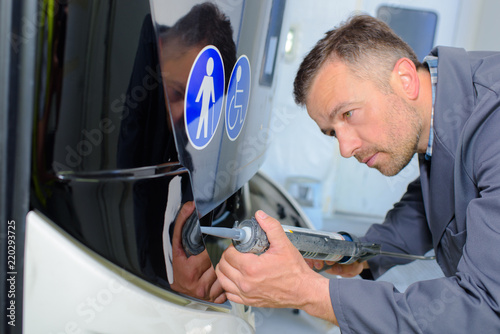 Man fitting panel to bus photo