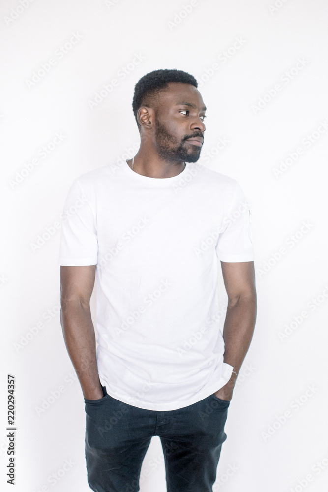 Positive human emotions, facial expressions, feelings, attitude and reaction. Friendly-looking young African American man dressed in white t-shirt and jeans posing in studio on white background Positive human emotions, facial expressions, feelings, attitude and reaction. Friendly-looking young African American man dressed in white t-shirt and jeans posing in studio on white background