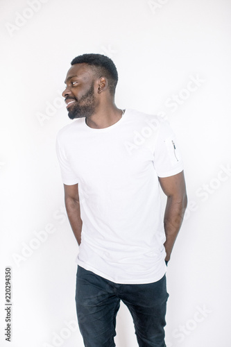 Positive human emotions, facial expressions, feelings, attitude and reaction. Friendly-looking young African American man dressed in white t-shirt and jeans posing in studio on white background