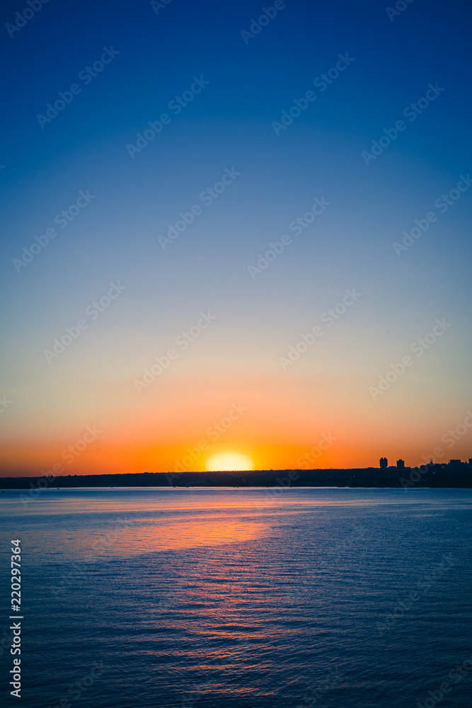 Sunset view from the Paranoa lake in Brasilia near by JK Bridge. In this photo: blue sky, orange and vivid sunset, blue lake without motion.