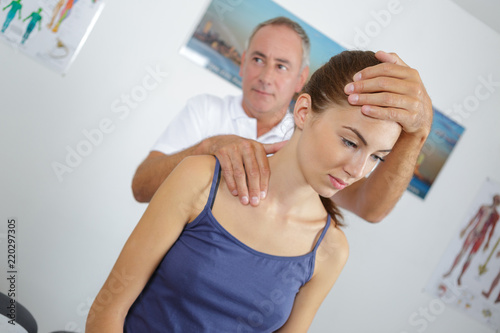 physiotherapist giving neck massage to a woman in clinic © auremar