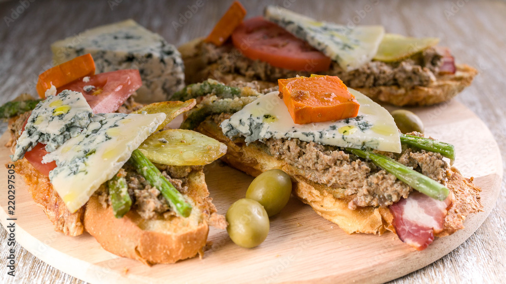 Italian sandwiches with mushroom pate, vegetables and cheese. Mediterranean traditional cuisine. Close-up